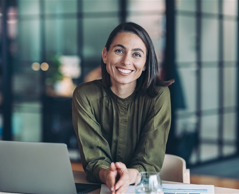 Profissional do time da Contabilidade.com sorrindo em sua mesa de trabalho