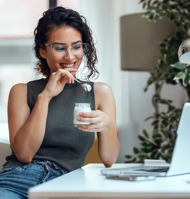 Mulher sorrindo enquanto consulta informações de uma empresa no notebook